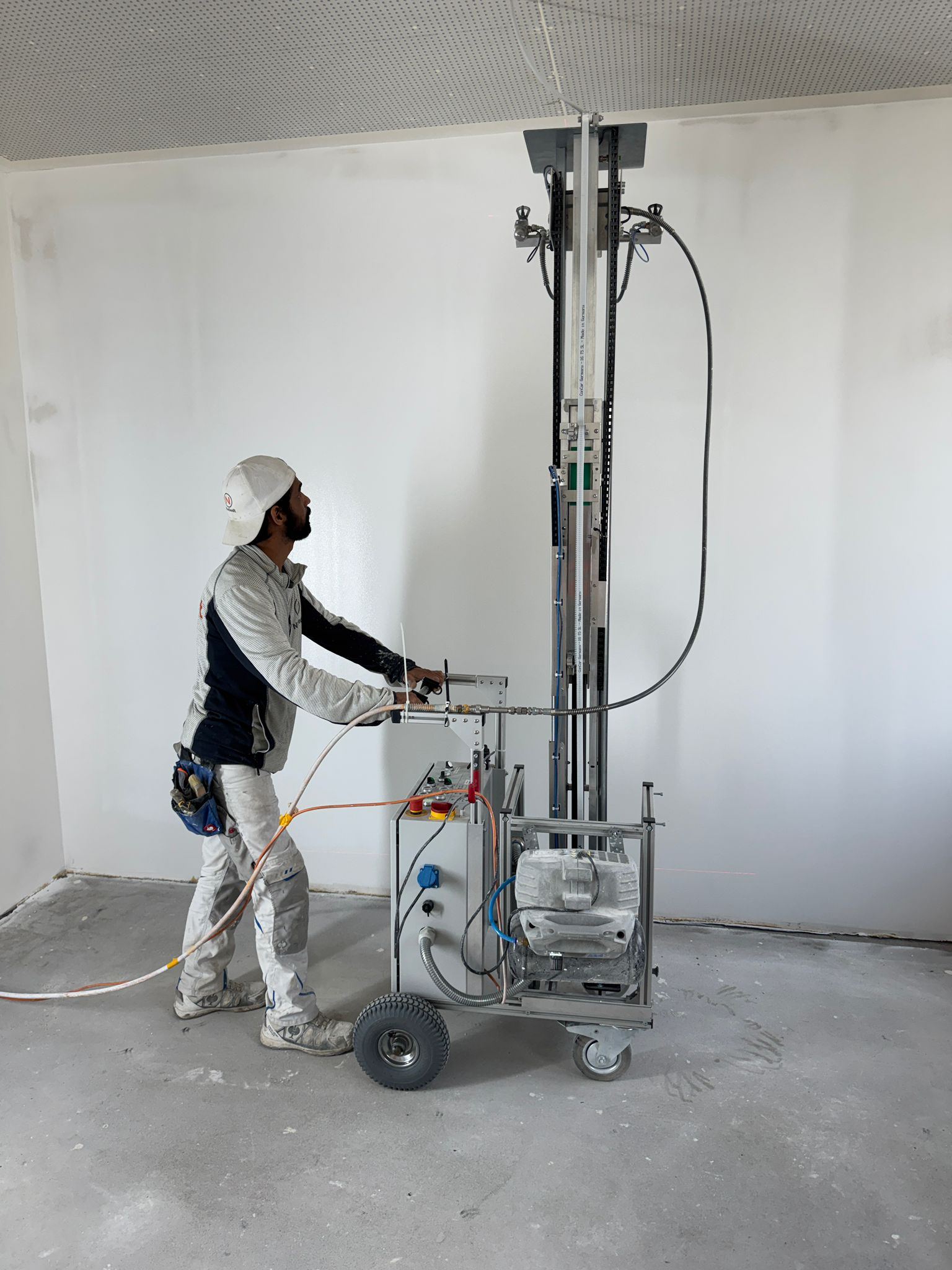 RSX Painter spray painting a wall on a construction site, operator at the controls