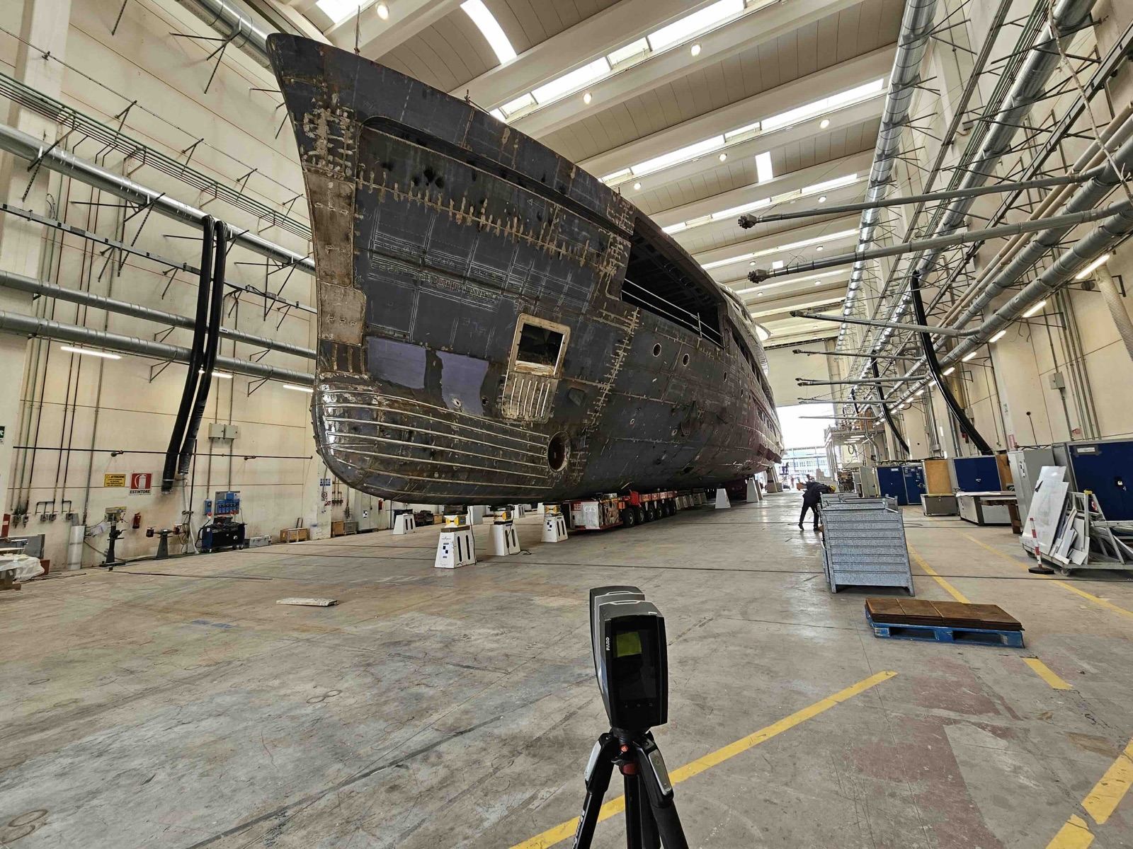 Superyacht hull in a shipyard hall with 3D laser scanner