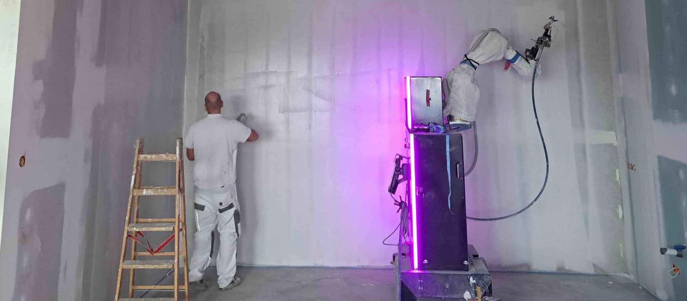 Robosurf Wizard autonomous mobile robot painter working on Construction Site with worker